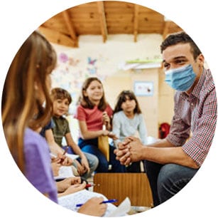 Image of teacher with students in the classroom